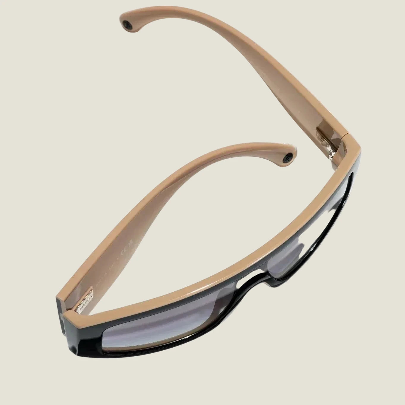 Image of Black and brown CHANEL sunglasses with plastic frame and adjustable nose pads, offering 100% UVA/UVB protection.
