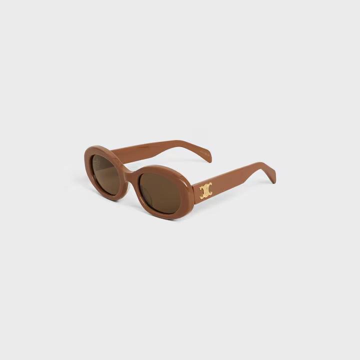 Image of Celine sunglasses with brown round frames and tinted lenses featuring the logo on the temples.