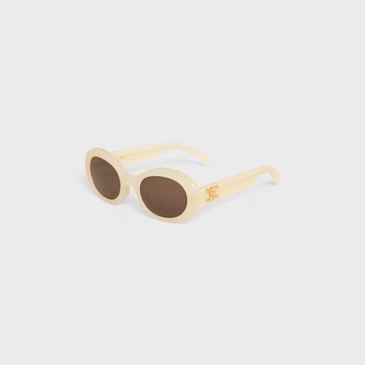 Celine sunglasses with cream oval frames and dark lenses featuring logo detail.