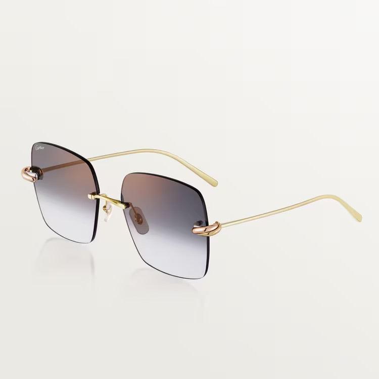 Image of Cartier luxury sunglasses with gold metal frame and UV400 lenses.