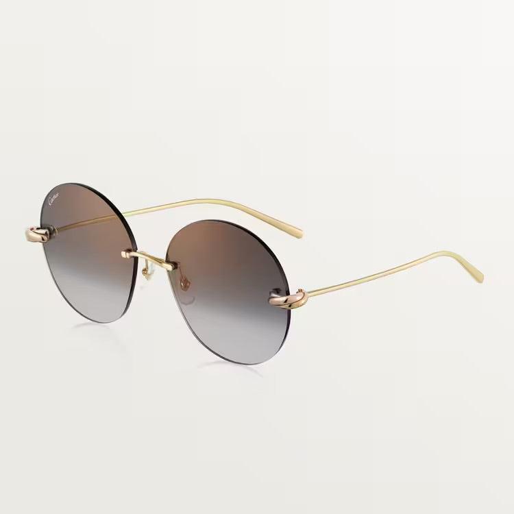 Image of Elegant Cartier sunglasses with gold metal frame and UV400 lenses.
