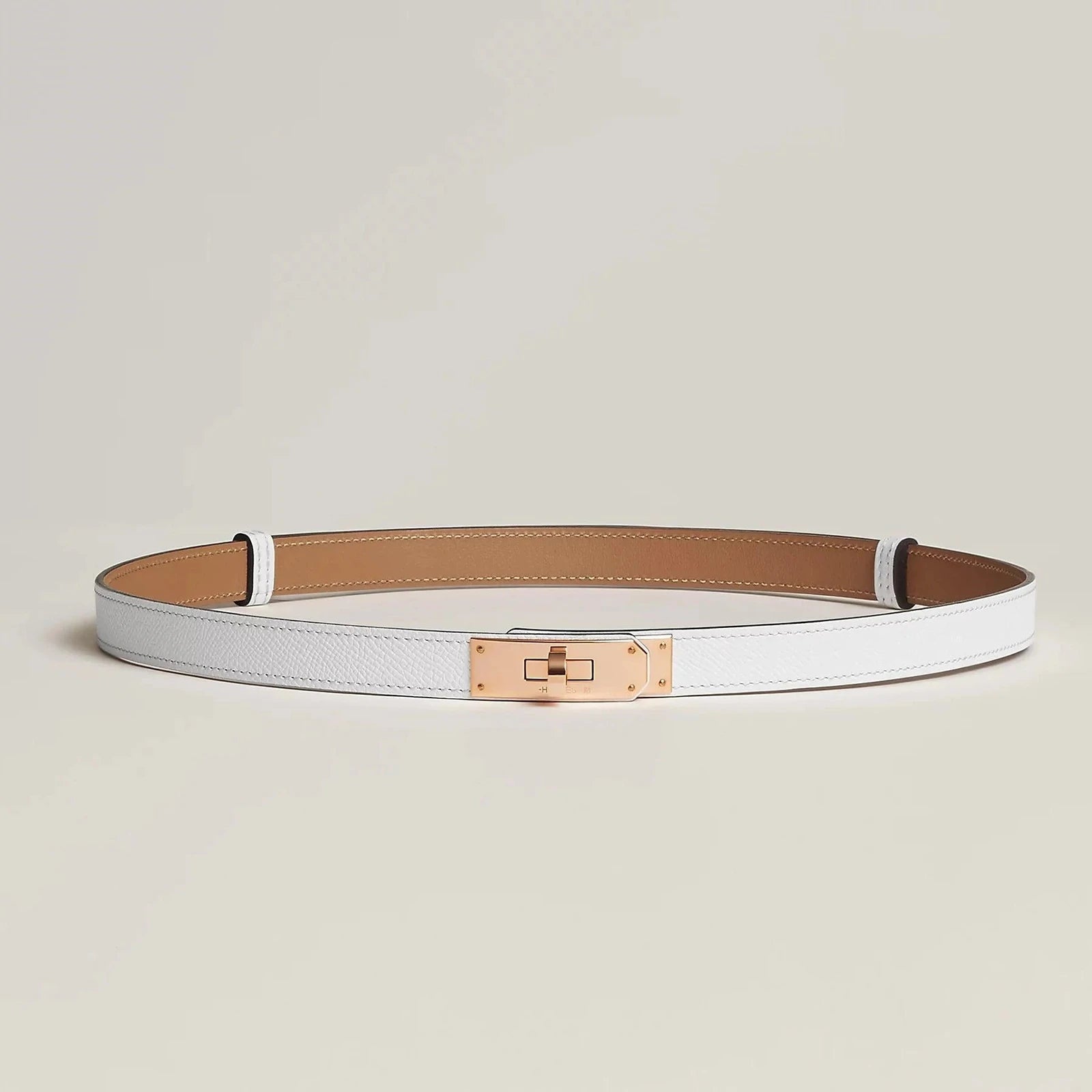 Image of Hermès Kelly belt in premium leather with minimalist gold buckle, elegant unisex design.