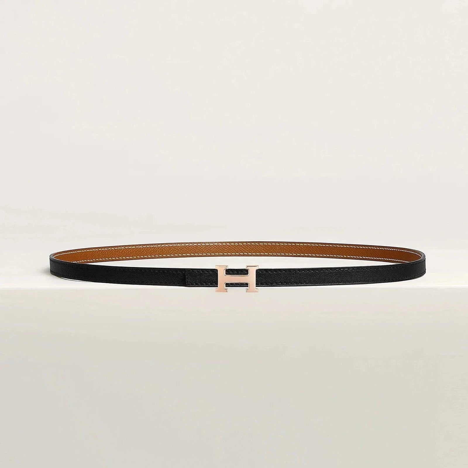 Image of Hermès belt with elegant metallic buckle, premium quality leather, versatile for men and women.