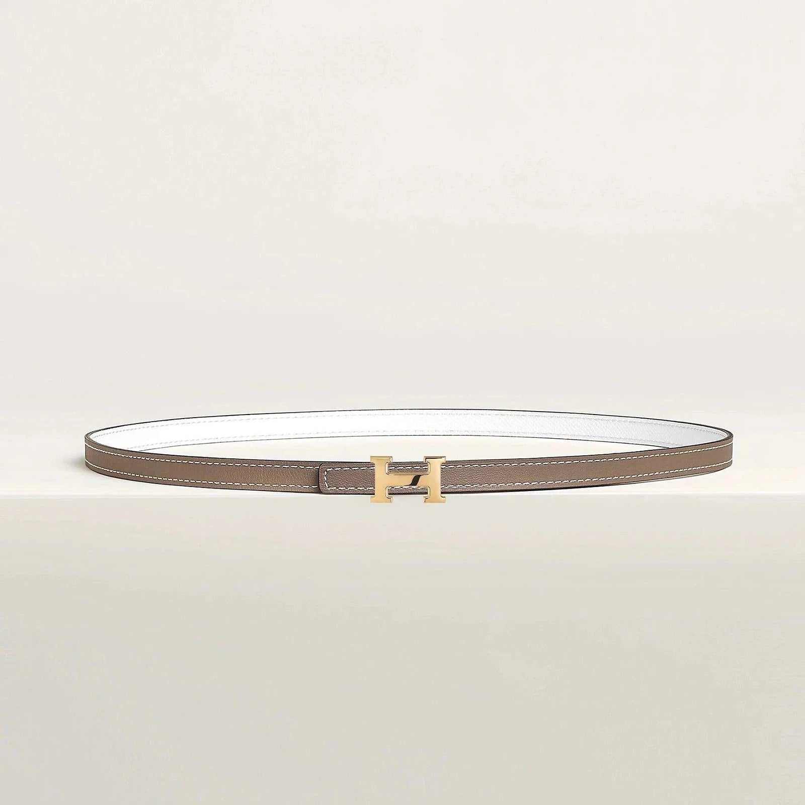 Hermes leather belt with gold H buckle, luxury reversible design.
