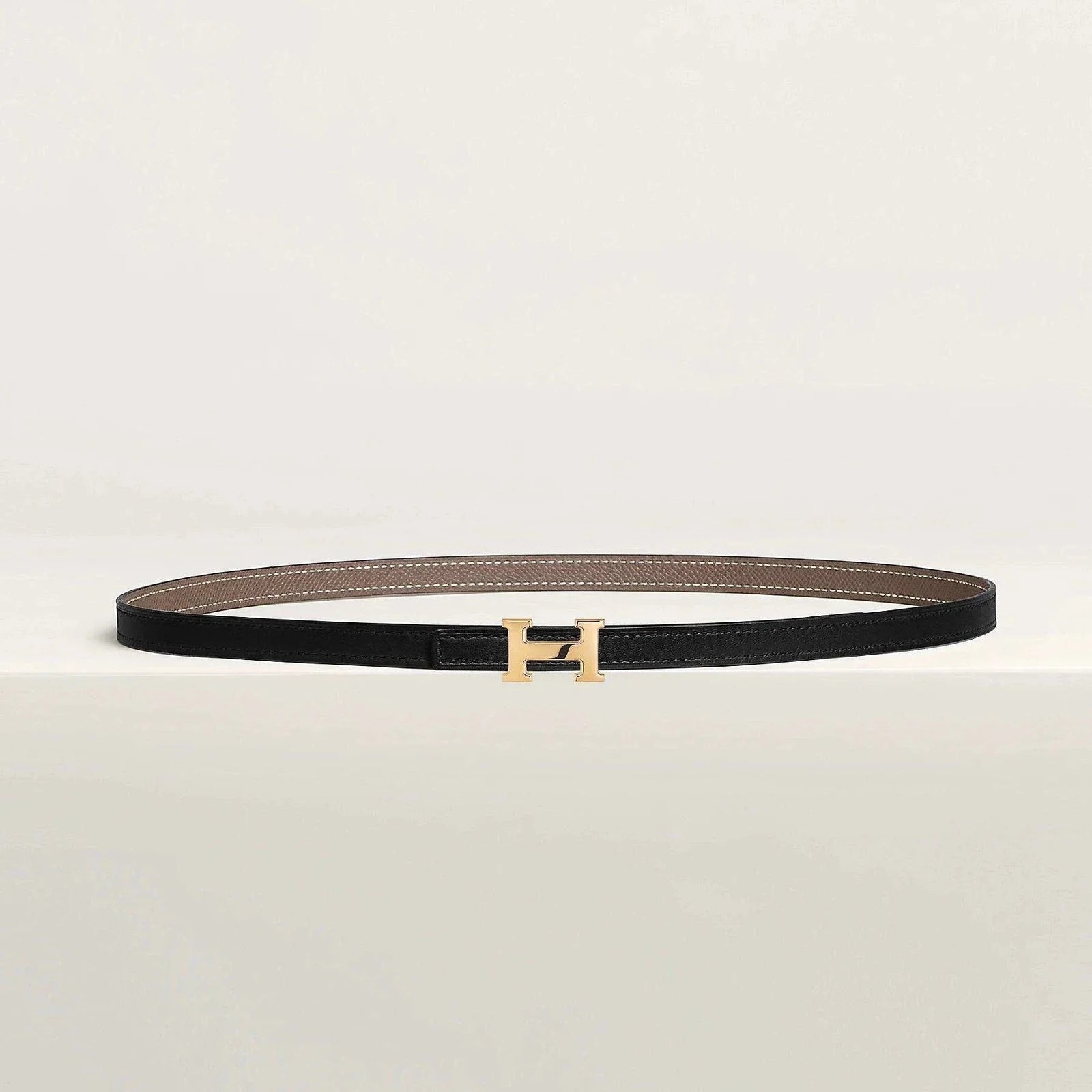 Luxury Hermès belt with gold buckle and minimalist design, crafted from premium leather.