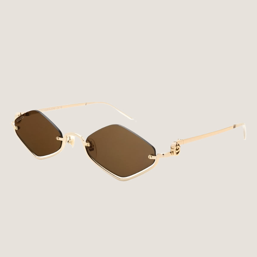 Image of Designer Gucci sunglasses with gold frames and dark lenses, offering UV400 protection.