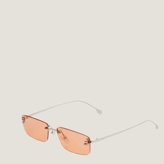 Image of Fendi luxury Italian sunglasses with orange lenses and sleek metal frames.