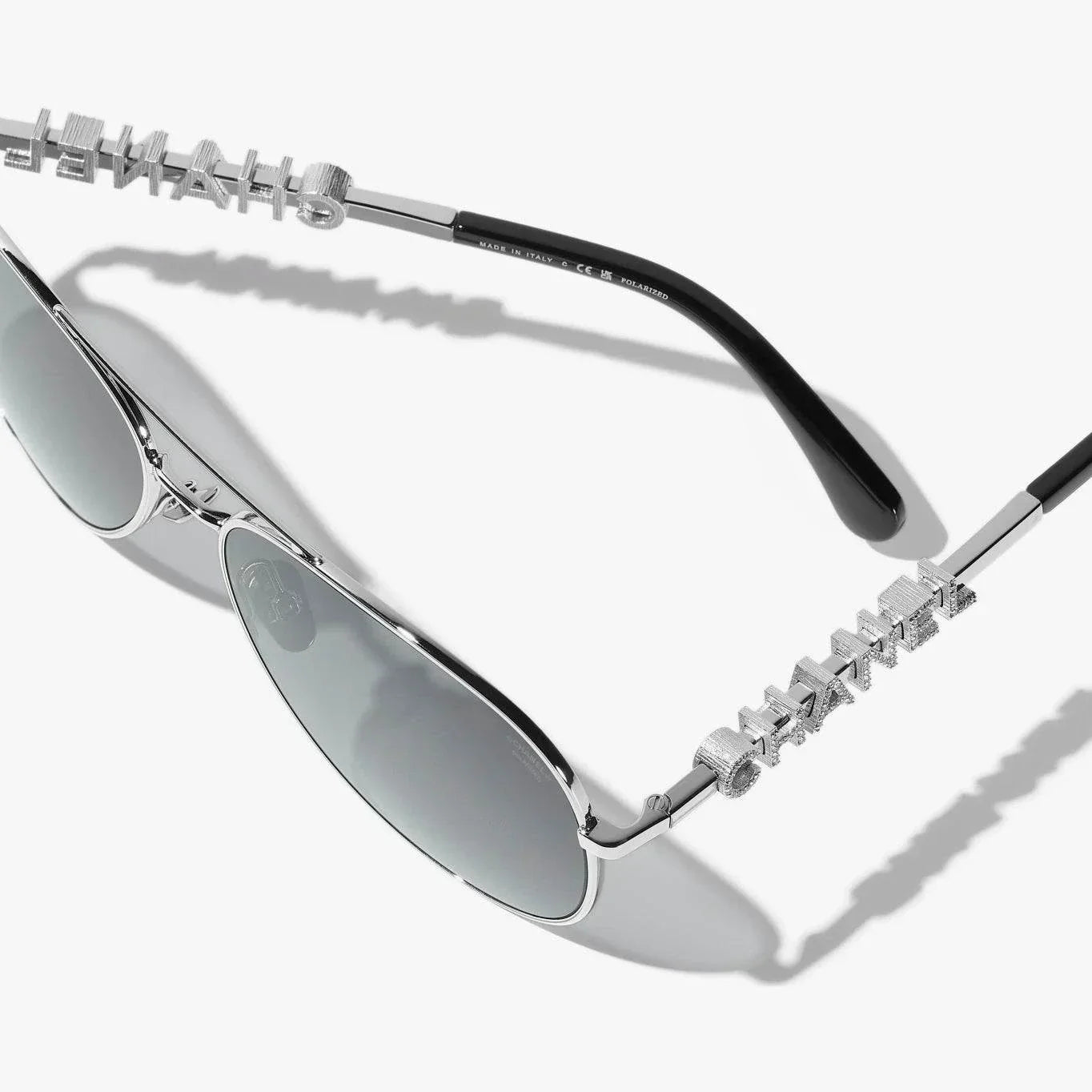 Image of Silver CHANEL sunglasses with plastic frame, UVA/UVB protection, adjustable nose pads.